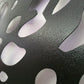 Macro close-up detail of black wrinkle shiny color powder coated laser cut metal panel surface finish