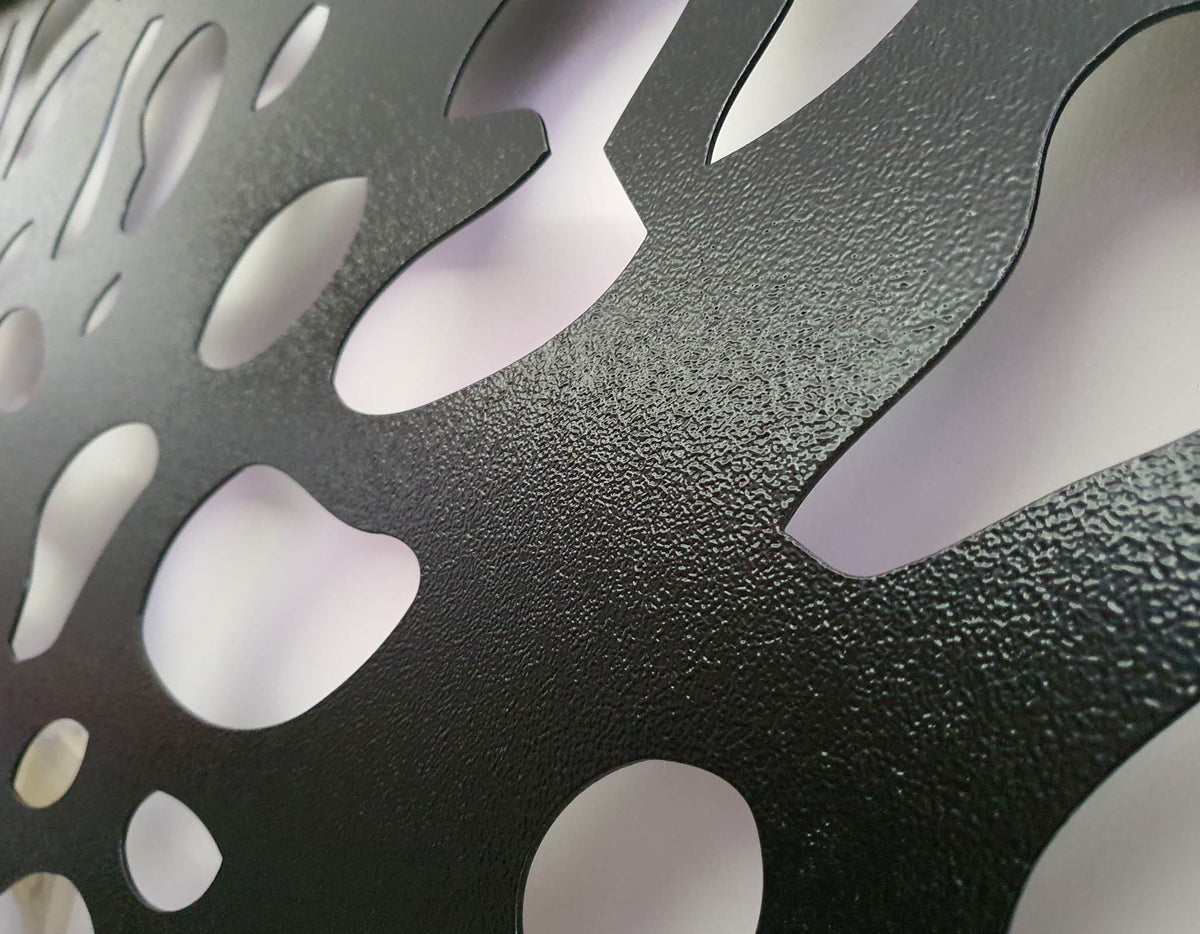 Macro close-up detail of black wrinkle shiny color powder coated laser cut metal panel surface finish