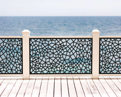 Black powder coated laser cut metal deck railing insert panel featuring Voronoi organic cell pattern installed on oceanfront wooden deck