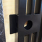 Macro close-up detail of black powder coated metal pedestrian gate lock box housing and catch plate