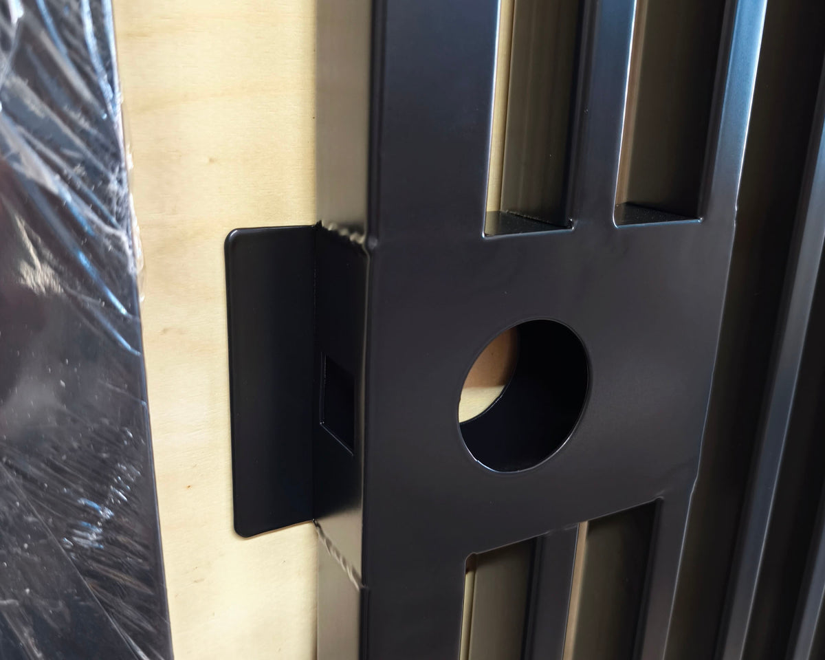 Macro close-up detail of black powder coated metal pedestrian gate lock box housing and catch plate