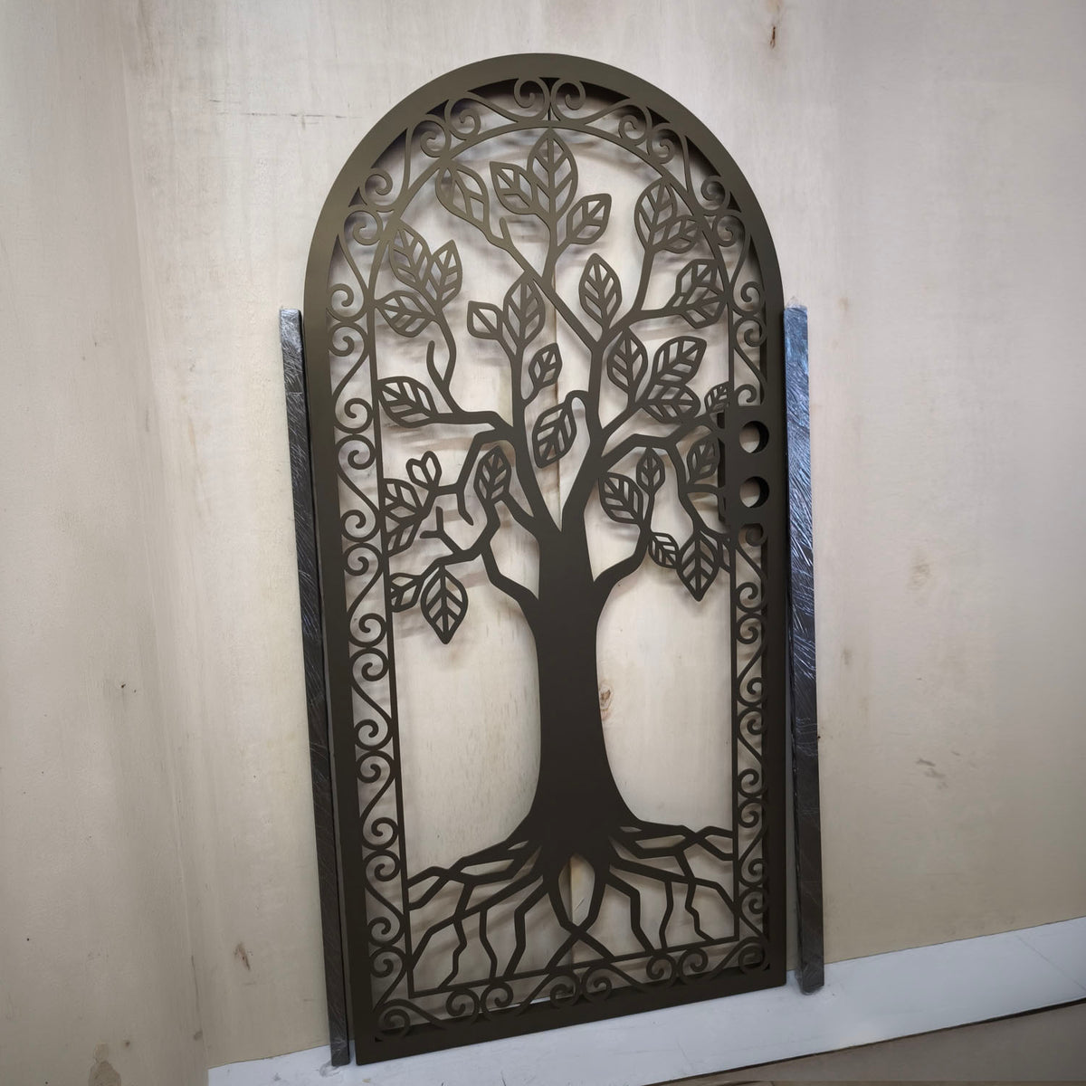 bronze laser cut metal door featuring tree of life design with roots and leaves