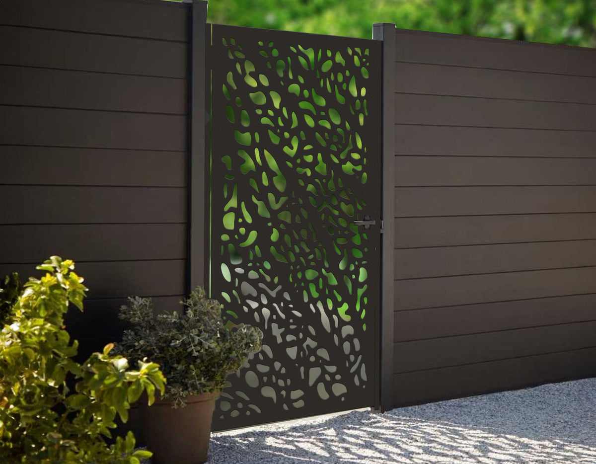 Matte black powder coated laser cut metal pedestrian garden gate featuring abstract pebble cell pattern installed with composite fence panels