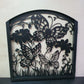 Matte black metal laser cut pedestrian garden gate featuring curved arched top frame with butterflies and botanical wildflower pattern