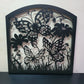 Black metal laser cut pedestrian garden gate featuring curved arched top frame with butterflies and botanical wildflower pattern