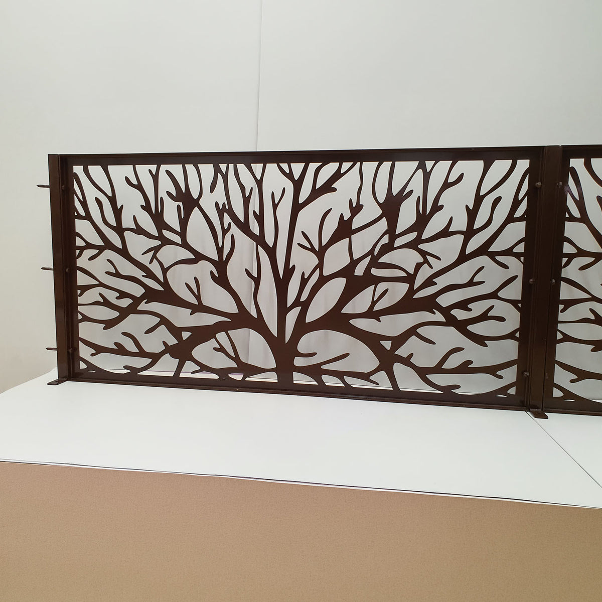 Dark brown metal laser cut fence railing panel featuring organic tree branch and coral silhouette pattern