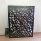 Matte black powder coated laser cut metal pedestrian garden gate featuring abstract pebble cell pattern installed with composite fence panels