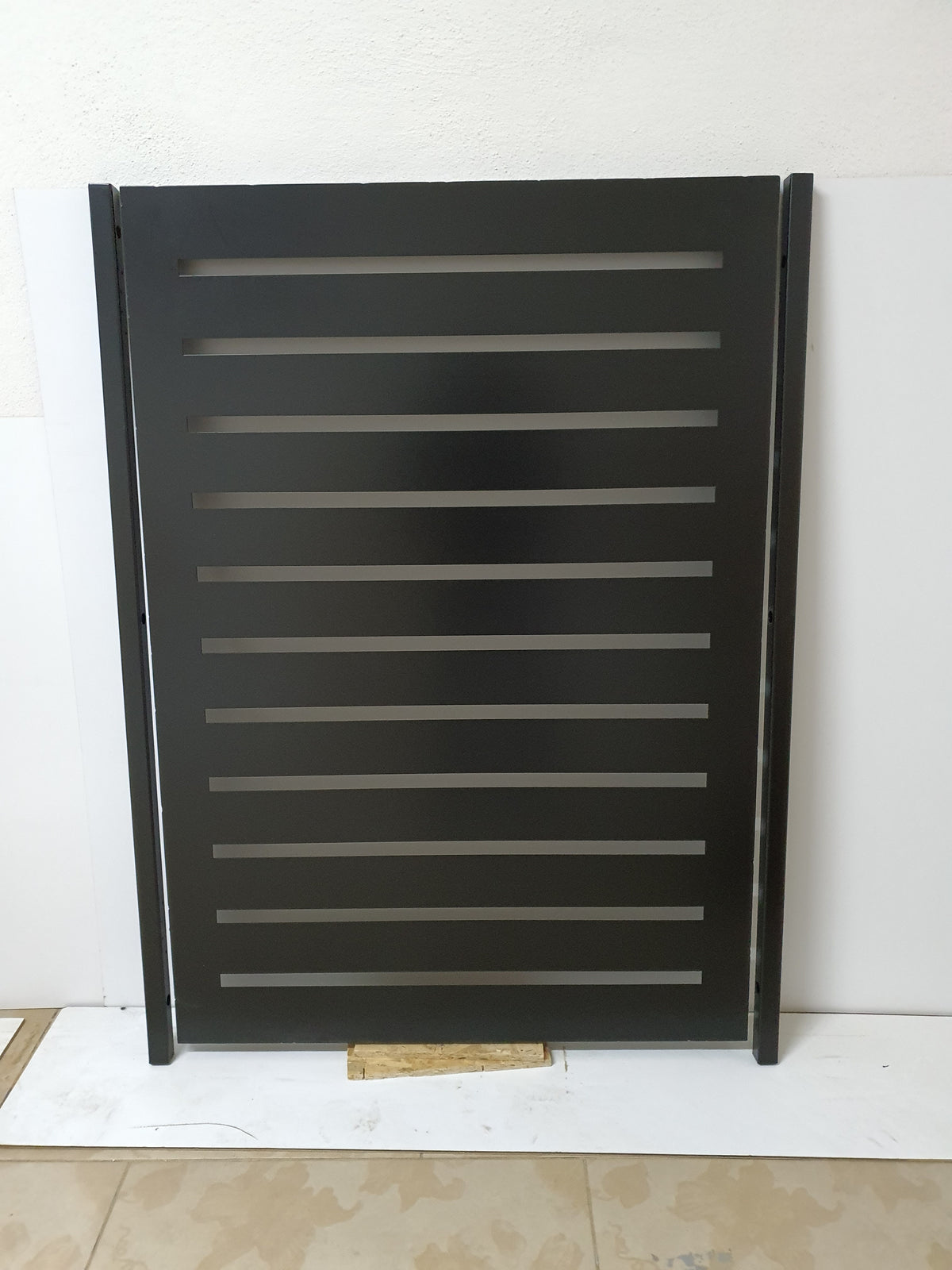 Black powder coated laser cut metal privacy garden gate featuring modern horizontal slat cutouts with side mounting posts