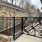 Matte black powder coated laser cut metal side pedestrian gate featuring large monarch butterfly wing and flower pattern