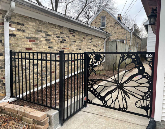 Matte black powder coated laser cut metal side pedestrian gate featuring large monarch butterfly wing and flower pattern