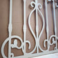 White powder coated laser cut metal outdoor deck railing panel featuring traditional wrought iron scrollwork installed on seaside wooden patio