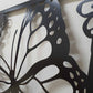 Black powder coated laser cut metal garden entrance featuring large monarch butterfly wing detail