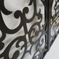 Black powder coated laser cut metal pedestrian garden gate featuring ornate scrollwork and circular medallion pattern