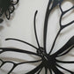 Matte black laser cut metal side pedestrian gate featuring large monarch butterfly wing and flower pattern