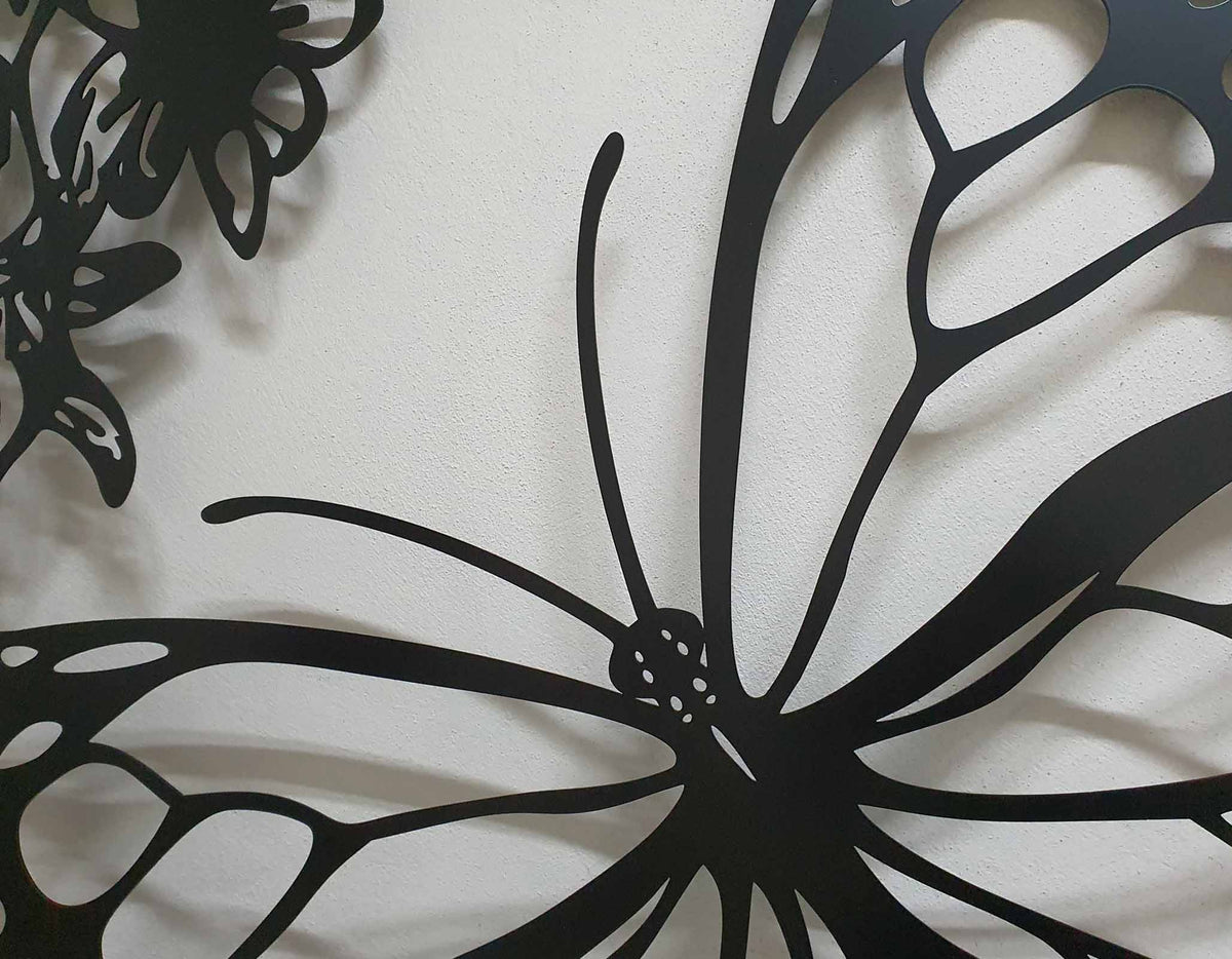 Matte black laser cut metal side pedestrian gate featuring large monarch butterfly wing and flower pattern