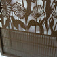 Metal garden gate with arched top frame featuring central daisy flower garden pattern and vertical slatted bars