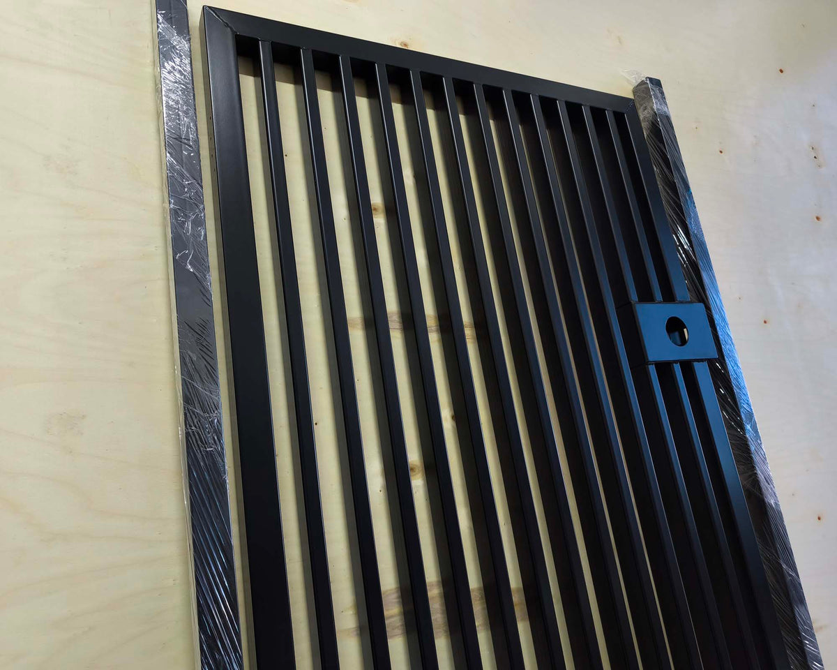 Metal pedestrian garden gate featuring vertical slatted bar pattern and side mounting posts