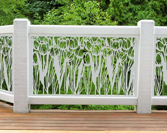 White powder coated laser cut metal balcony railing insert panel featuring floral tulip flower garden pattern installed on outdoor wooden deck