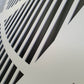 Close-up detail of white powder coated laser cut metal panel with geometric vertical slatted pattern