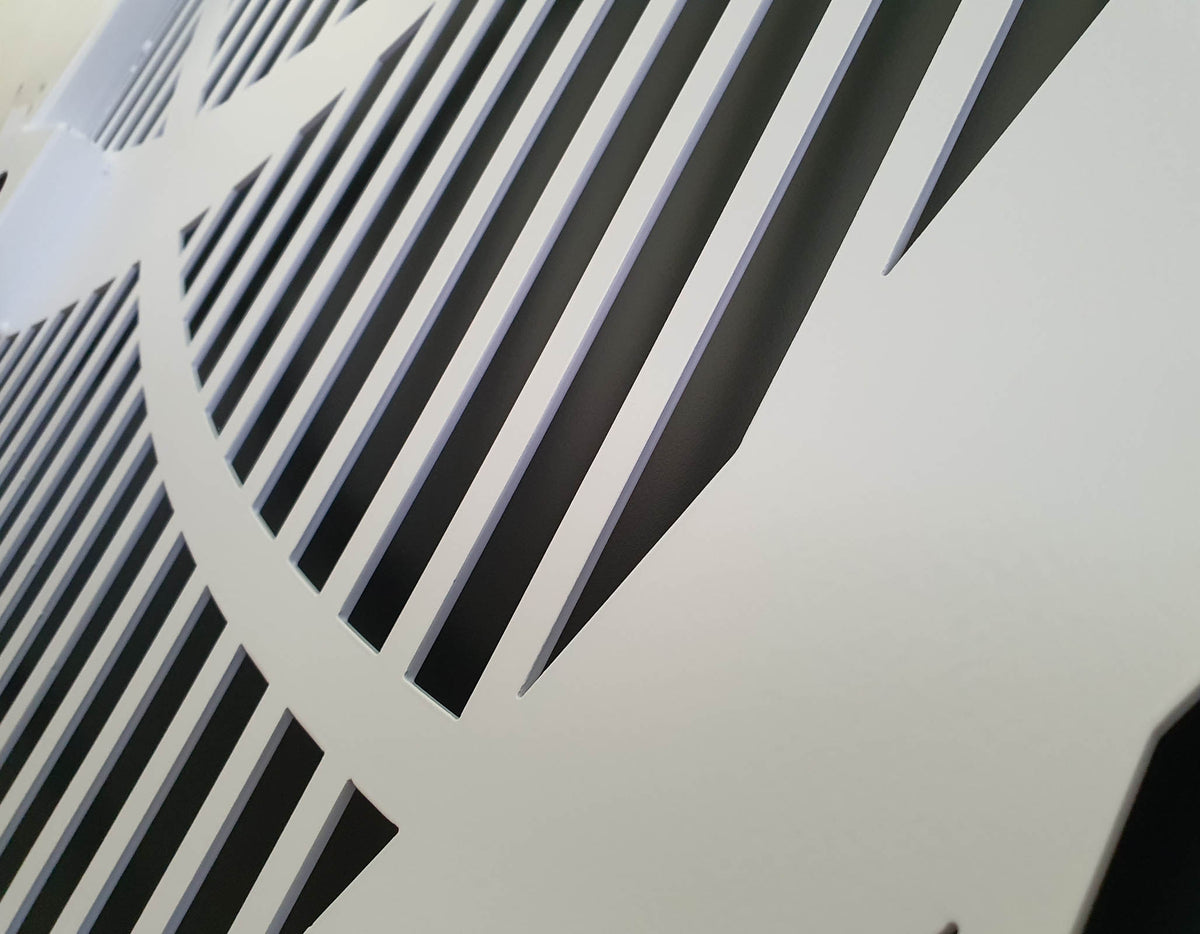 Close-up detail of white powder coated laser cut metal panel with geometric vertical slatted pattern