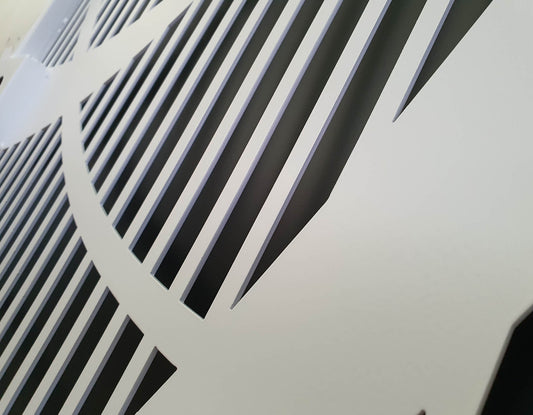 Close-up detail of white powder coated laser cut metal panel with geometric vertical slatted pattern
