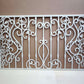 White powder coated laser cut metal fireplace screen panel featuring traditional wrought iron scrollwork and ornate bar pattern