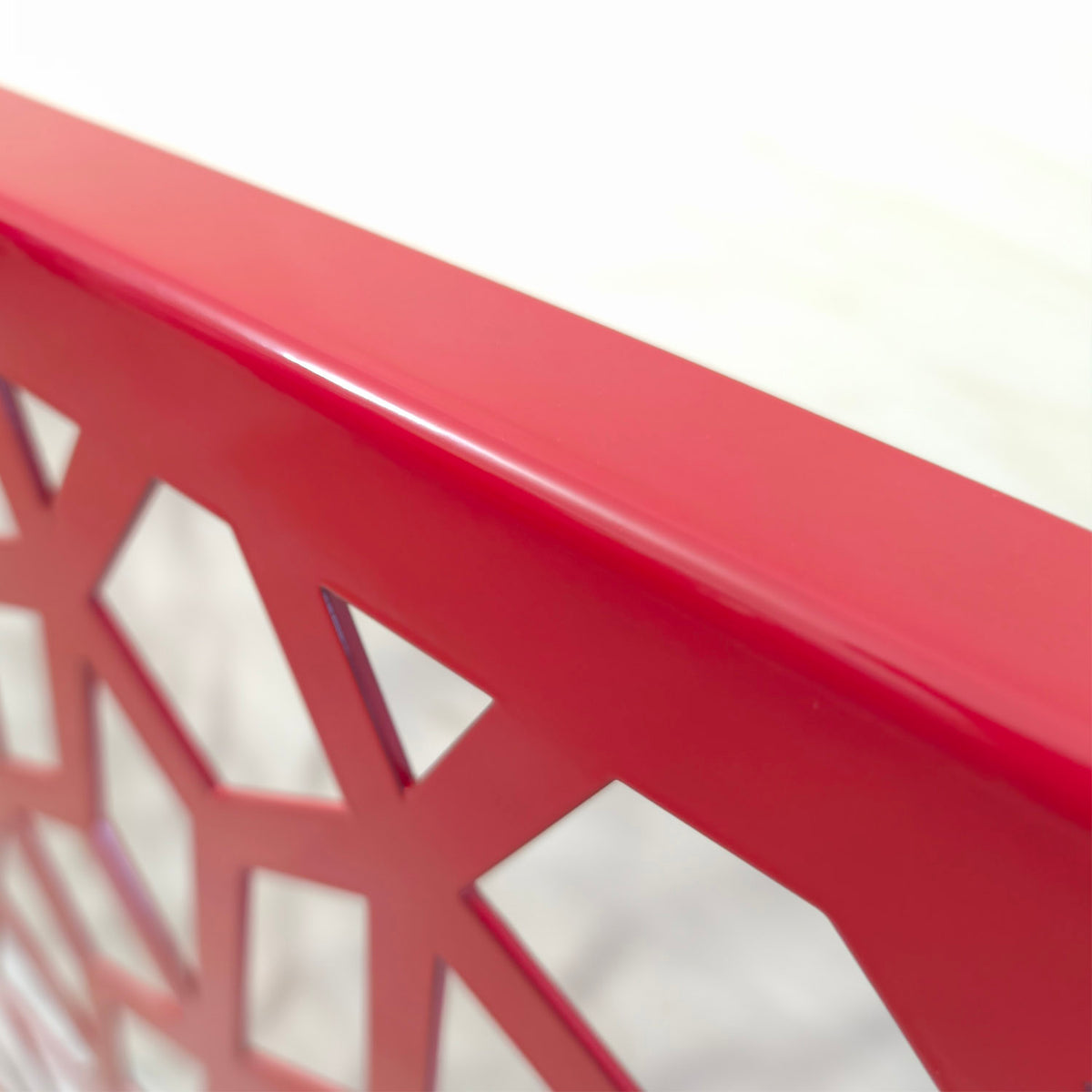 Bent edge detail of a honeycomb Voronoi laser cut steel panel in glossy red powder coat
