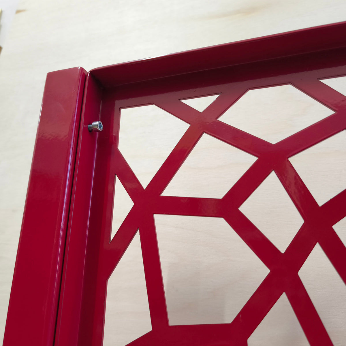 Close-up of the bolted connection between a honeycomb Voronoi metal railing panel and its steel post