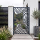 Laser cut metal garden gate with a cobblestone spiral vortex pattern in matte anthracite grey (RAL 7016), installed at a modern minimalist house side entrance.