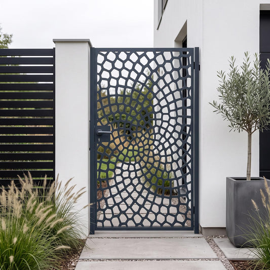 Laser cut metal garden gate with a cobblestone spiral vortex pattern in matte anthracite grey (RAL 7016), installed at a modern minimalist house side entrance.