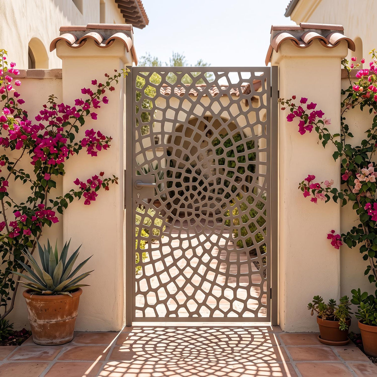 Laser cut metal garden gate with a cobblestone spiral vortex pattern in matte beige grey (RAL 7006), set in a Spanish-style courtyard with stucco pillars and pink bougainvillea.